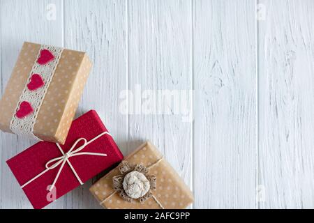 Three gifts close up on a light wooden background with a place for copy space. Frame for text with boxes of presents. Stock Photo