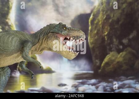 Tyrannosaurus with open mouth in cretaceous era with waterfall in the background. Lateral view Stock Photo