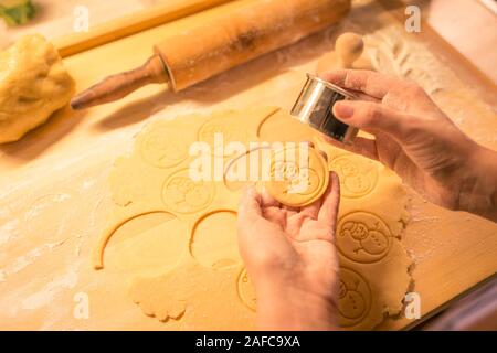 Stamped Christmas Sugar Cookie Dough, Made With Love, Snowman theme. Sinhle war cookie in womans hands. Christmas candy. Stock Photo