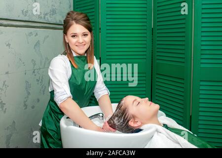 Young woman getting a hair wash before haircut in beauty salon. Stock Photo