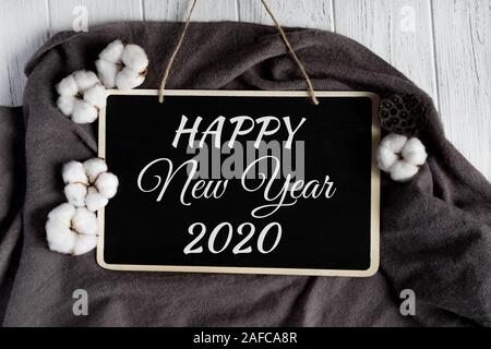Happy New Year. Greeting Christmas card with cotton flowers on a whitewashed wooden background. Congratulatory New Year banner Stock Photo