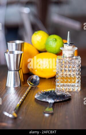 Set of a bartender accessories with little bottles of essenceand fruits on a dark wooden table Stock Photo