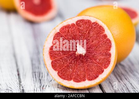 Portion of sliced Grapefruits on an old wooden table (selective focus; close-up shot) Stock Photo