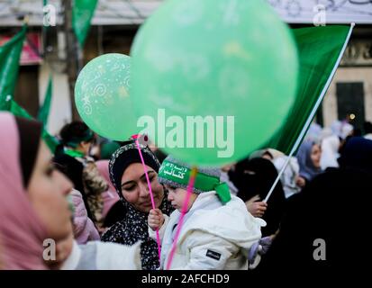 A kid with a Hamas headband while holding a balloon during a rally marking the 32nd anniversary of the founding of the Islamist movement Hamas. Stock Photo