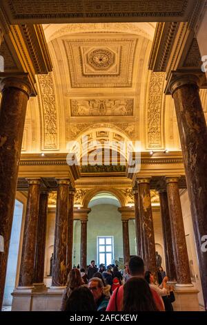 Interior of the Louvre Museum in Paris city with people and visitors walking and taking photos