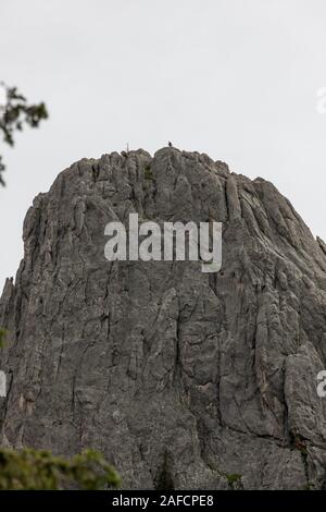 A couple of people standing on top of a giant quartz rock formation with a cloudy background in Custer State Park, South Dakota. Stock Photo