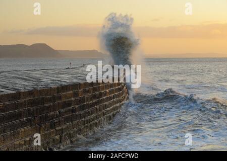 Big waves splashing on the Cobb in Lyme Regis, Dorset caused by gusty winds during high tide Stock Photo