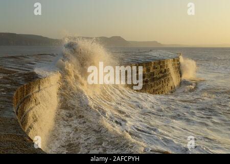 Big waves splashing on the Cobb in Lyme Regis, Dorset caused by gusty winds during high tide Stock Photo