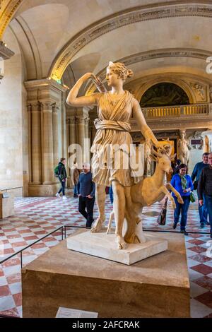 Interior of the Louvre Museum in Paris city with people and visitors walking and taking photos