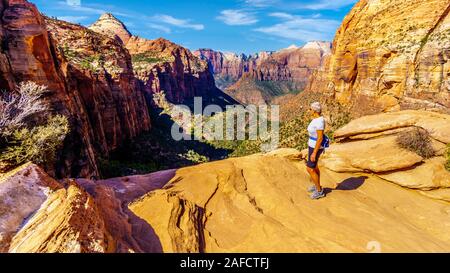 Active Senior Woman looking into Zion Canyon from the top of the Canyon Overlook Trail in Zion National Park, Utah, United States Stock Photo