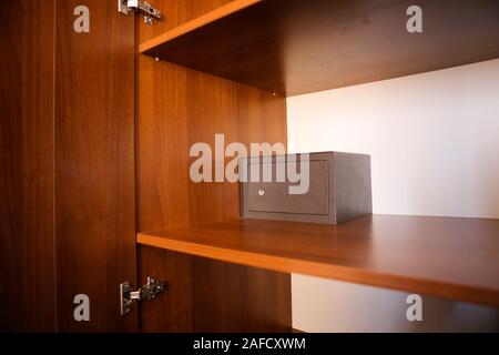 Metal safe inside an empty wooden closet in a hotel room Stock Photo