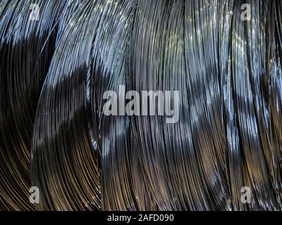 Closeup background of metal wire roll in silver color. Building material. Texture with selective focus and blur. Stock Photo
