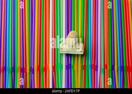 Drinking straws. Abstract background with many multi colored plastic tubules for juice or cocktail, single-use disposable. And two bottle caps in the Stock Photo