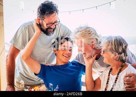 Family caucasian portrait of happy cheerful family with three generations from grandson to son and grandfathers all together having fun and love - con Stock Photo