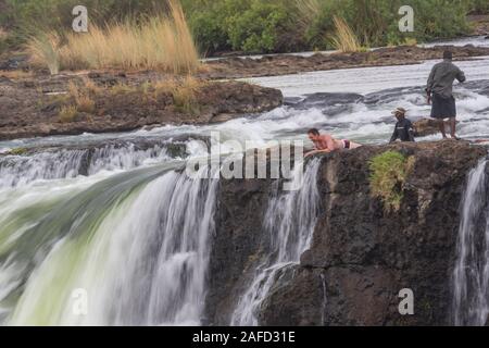 Victoria Falls, Zimbabwe/Zambia. tourists in Livingstone Island, where in the dry season one could approach the Victoria falls from above and swim in the 'Devil's pool' just above the falls. Stock Photo