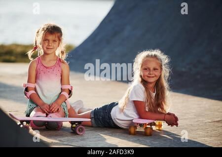 Posing for a camera. Unity of people. Two little friends in the park at daytime Stock Photo