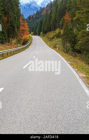 Winding forest road in beautiful autumn colors in Bavaria Alps, Berchtesgaden National Park in Germany Stock Photo