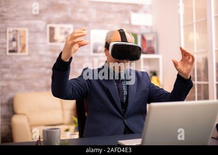 Elderly man experiencing new virtual reality technology for the first time in his home Stock Photo
