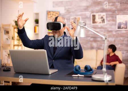 Elderly man experiencing new virtual reality technology for the first time in his home Stock Photo
