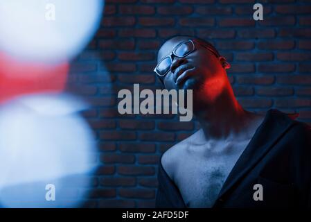 Light blinks. Futuristic neon. Young african american man in the studio Stock Photo