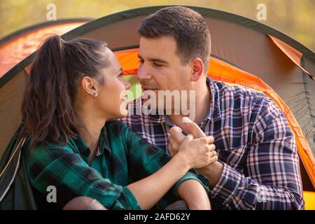Loving couple looking at each other in front of the tent. People together Stock Photo