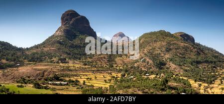 Ethiopia, Tigray, Adwa, agricultural fields at harvest time amongst dramatic volcanic landscape beside Axum to Adigrat highway, panoramic Stock Photo