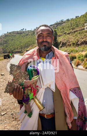 Ethiopia, Tigray, Adigrat, priest soliciting donations at roadside, holding large traditional bronze cross Stock Photo