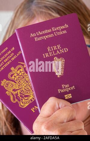 London, UK. 15th December 2019. The Irish government are expecting a surge in applications for Irish passports from UK residents who are able to claim their entitlement to Irish citizenship if any of their parents or grandparents were born in Ireland. Dual citizenship is allowed for UK passport holders, and after Brexit the British holder of an Irish passport may see advantages during their travels within Europe. Woman holding both passports in front of her face. Credit: Mick Flynn/Alamy Live News Stock Photo