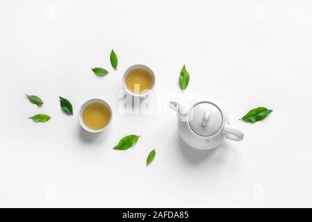 Green Tea Composition with tea leaves on white background. Chinese traditional tea set, tea culture concept, top view, copy space. Stock Photo