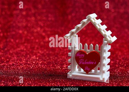 Little white house and red heart written with words 'Happy Valentine's Day ' on the red background for your design pattern or your valentine concept. Stock Photo