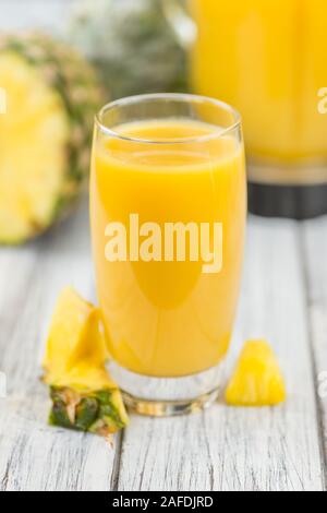 Fresh made Pineapple Juice on an old and rustic wooden table; selective focus; close-up shot Stock Photo