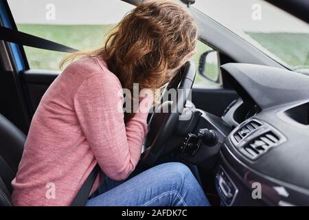 Stressed woman covering face with hands in car. Driver panic concept Stock Photo