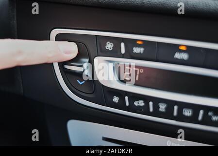 Woman hand set temperature on air conditioner panel in car. Climate control panel Stock Photo