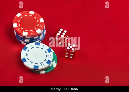 Dices and casino chips on red background. Gambling concept Stock Photo