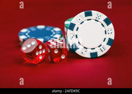 Dices and casino chips on red background. Gambling concept Stock Photo