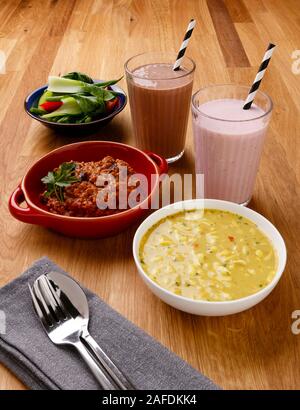 Calorie controlled daily meal plan, including breakfast, lunch and evening meal, with milkshake, shot on a wooden background Stock Photo