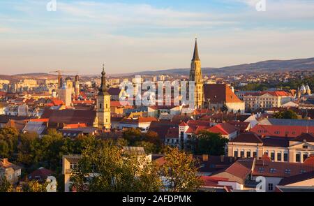 Aerial view of the Cluj Napoca old town with the bell towers of the Saint Michael's church and the Franciscan church during sunset. Romania. Stock Photo