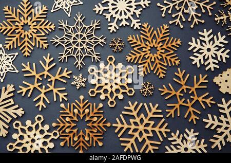 Handmade wooden snowflakes in flay lay on blue Christmas