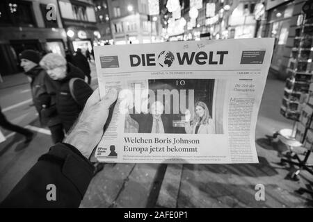 Paris, France - Dec 14, 2019: Man reading in the city German Die Welt newspaper portraying UK Prime Minister Boris Johnson and his partner Carrie Symonds after winning Early General elections Stock Photo