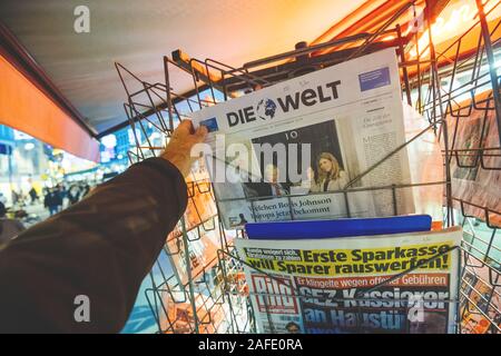 Paris, France - Dec 14, 2019: Man buy at press kiosk German Die Welt newspaper portraying UK Prime Minister Boris Johnson and his partner Carrie Symonds after winning Early General elections Stock Photo