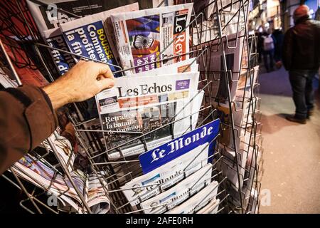 Paris, France - Dec 14, 2019: POV Man buy press kiosk the latest Les Echos French newspaper featuring news about recent French strikes related to pensions Stock Photo