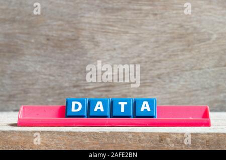 Tile letter on red rack in word data on wood background Stock Photo