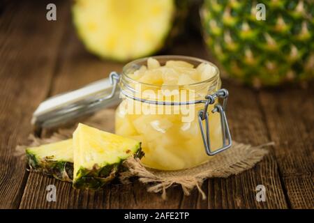 Fresh made Chopped Pineapple (preserved) on an old and rustic wooden table; selective focus; close-up shot Stock Photo