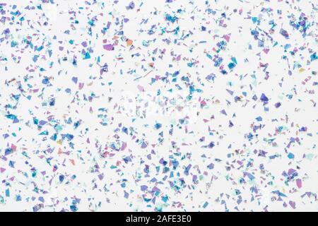 Glowing mica glitter confetti on white background. Festive abstract backdrop. Holiday Flat lay. Stock Photo