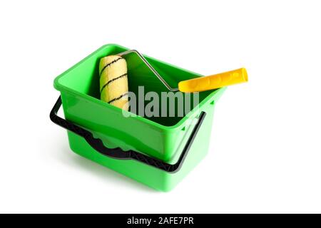 Paint roller in a green plastic bucket. Close-up. Isolated over white background. Stock Photo