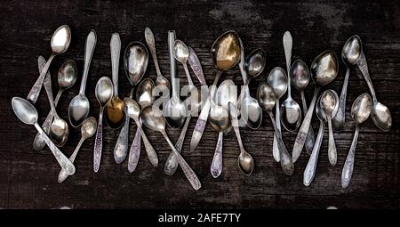 Vintage cutlery - spoons, forks and knives on an old wooden background. Selective focus. Stock Photo