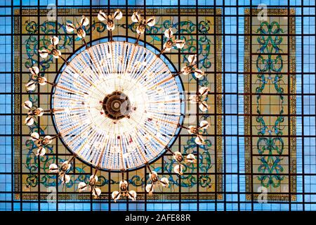 Background of large chandelier hanging on the ceiling. Venetian glass background. Luxury background. Lights on the chandelier in restaurant, hotel, resort. Stock Photo