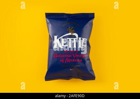 A packet of Kettle sea salt and balsamic vinegar of Modena crisps shot on a yellow background. Stock Photo