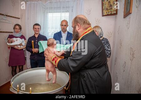 Malorita, Belarus - Octouber 1, 2017: washing the newborn in a tub during the christening ceremony in the local Orthodox Church Stock Photo