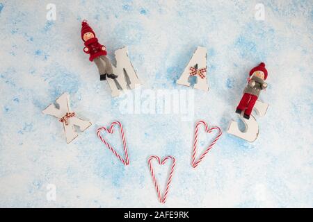 Title Xmas with with candy wooden white blue background. Christmas festive card, holidays Stock Photo